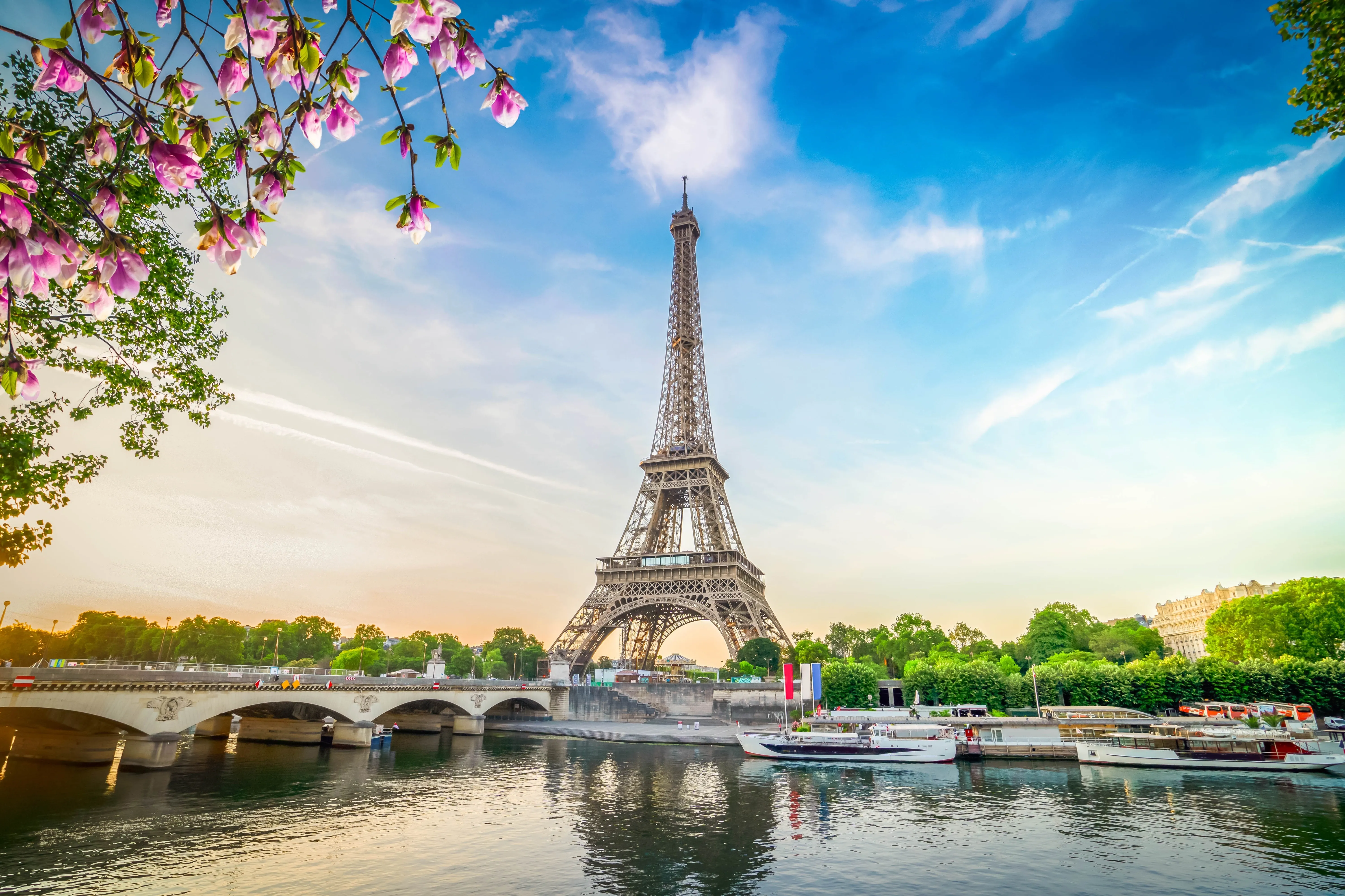 a classic golden hour sunset view of the Eiffel Tower in Paris, France, rising majestically above the Seine River.