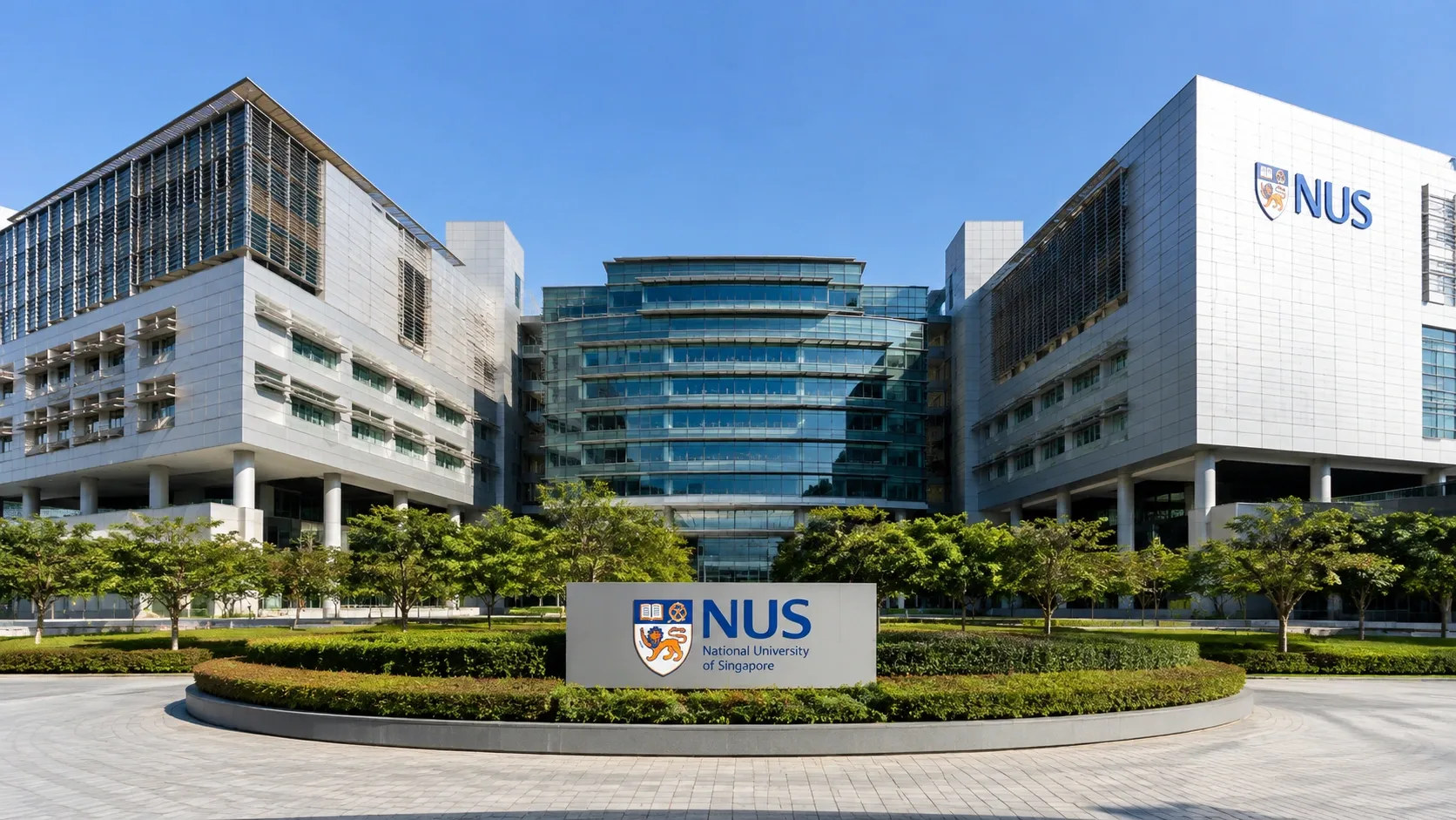 Modern National University of Singapore campus building with the NUS sign, landscaped greenery and a bright blue sky.