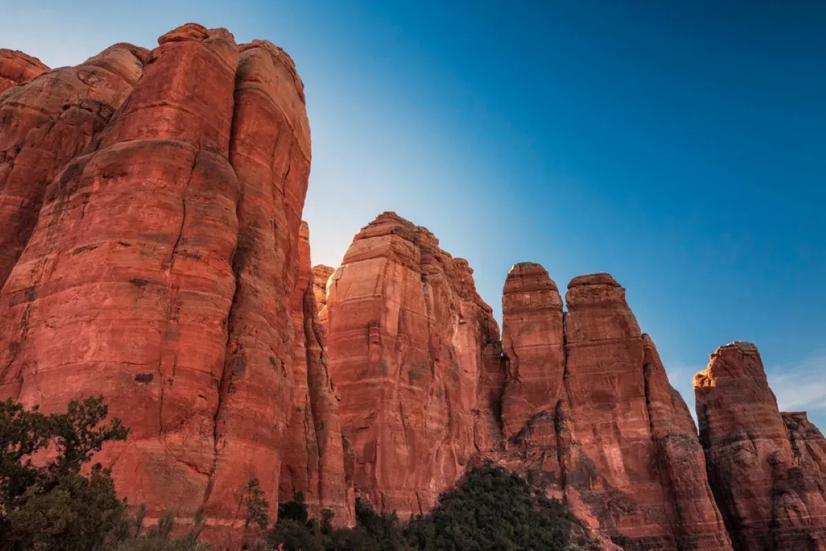 Red sandstone formations beneath a clear blue sky in the Arizona desert